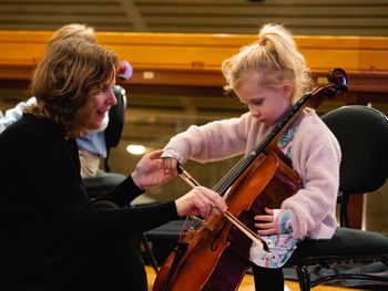 Jente som blir instruert i å spille cello